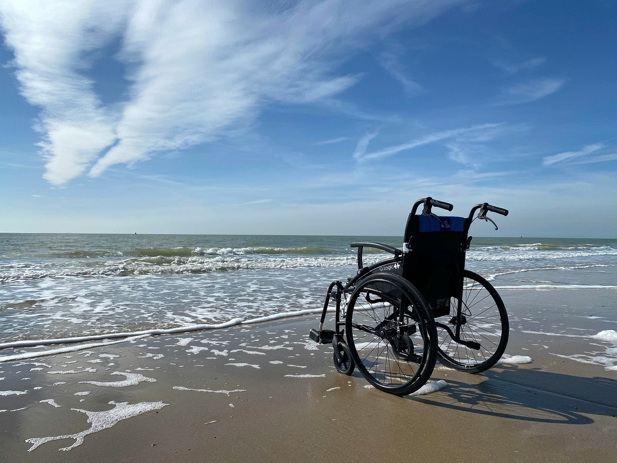 Rollstuhl am Strand. Wenn die Krankenkasse solche Hilfsmittel verweigert, kann unser Anwalt helfen.