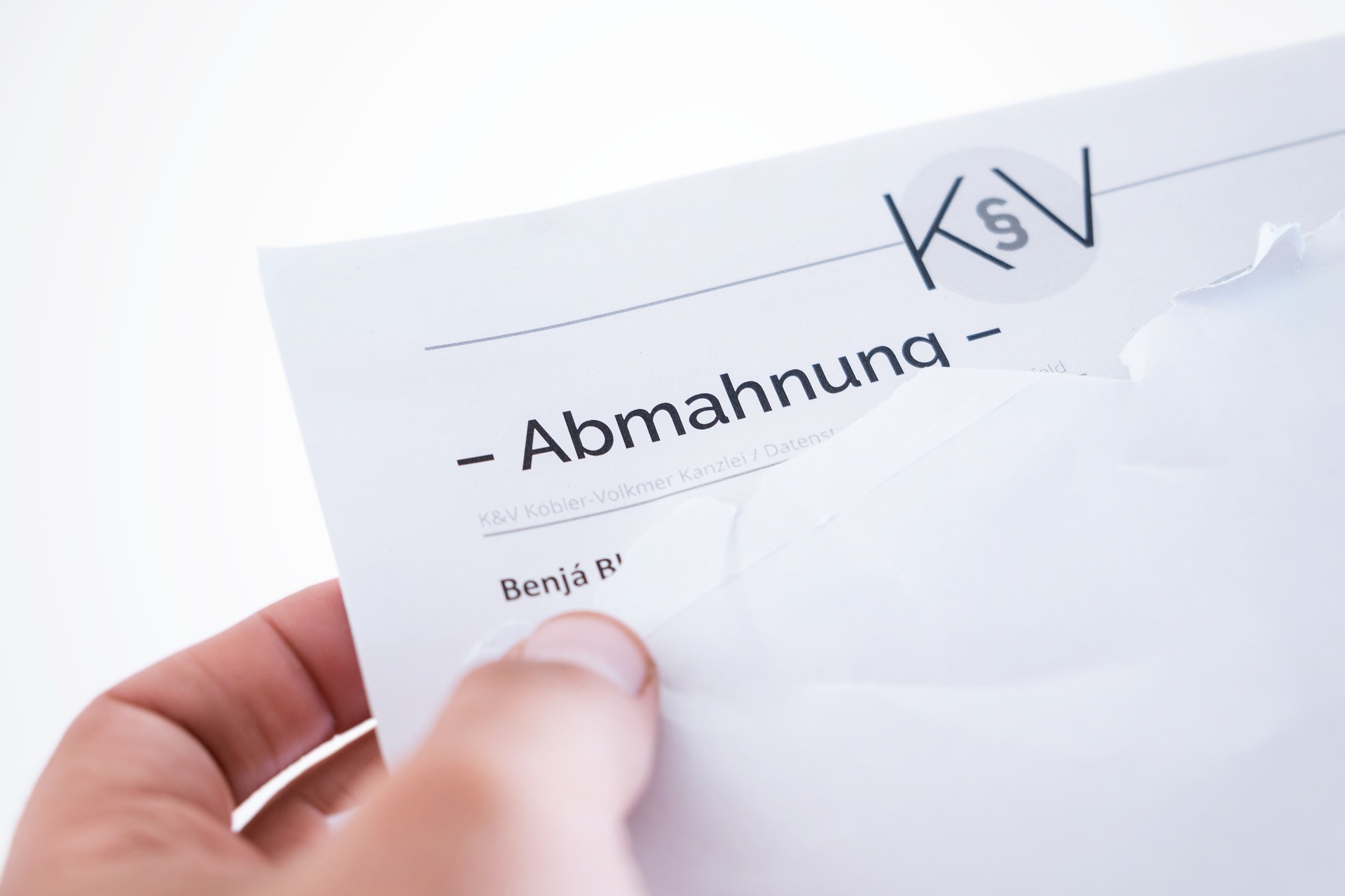 Ein Arbeitnehmer zieht ein Abmahnungs-Schreiben aus dem Umschlag.